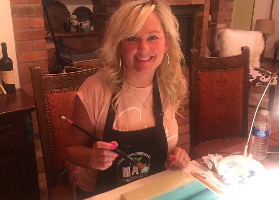 Amy painting at her table